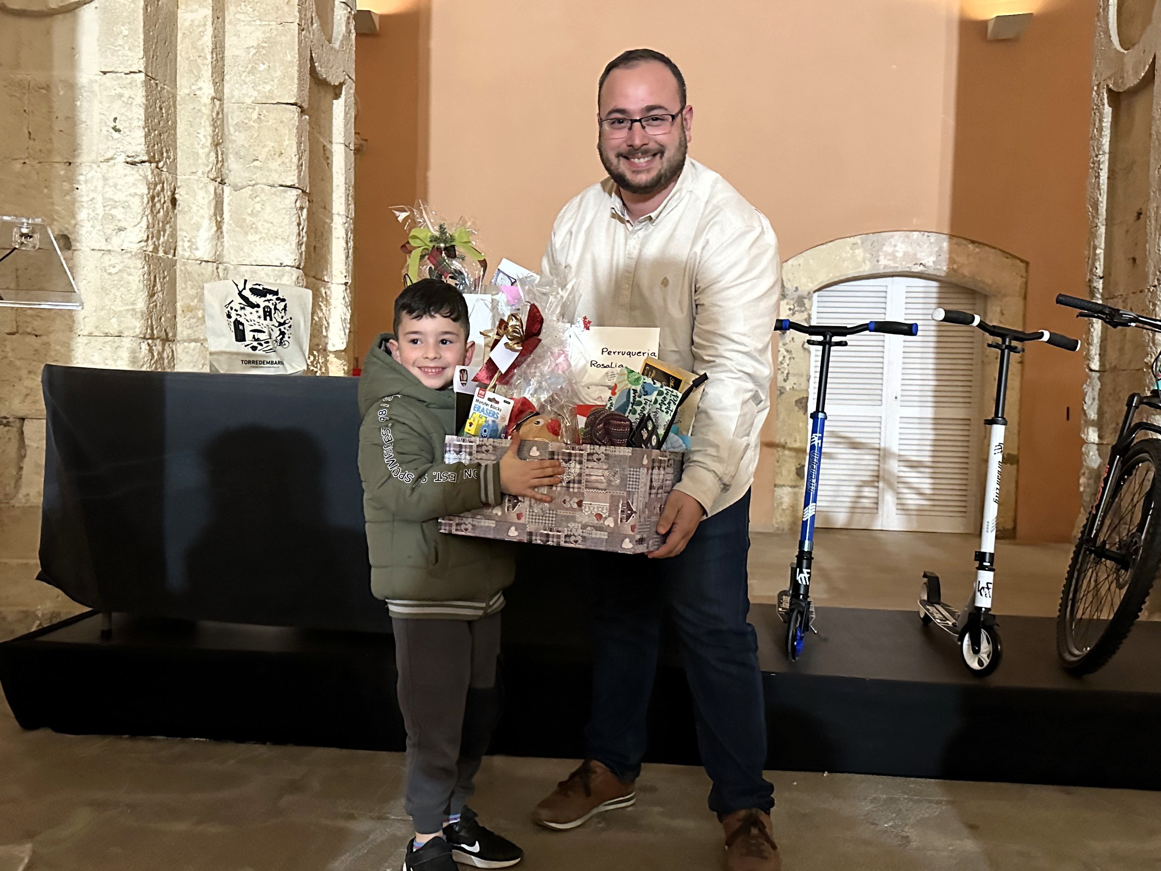 Lliurament d'una cistella de productes escolars.