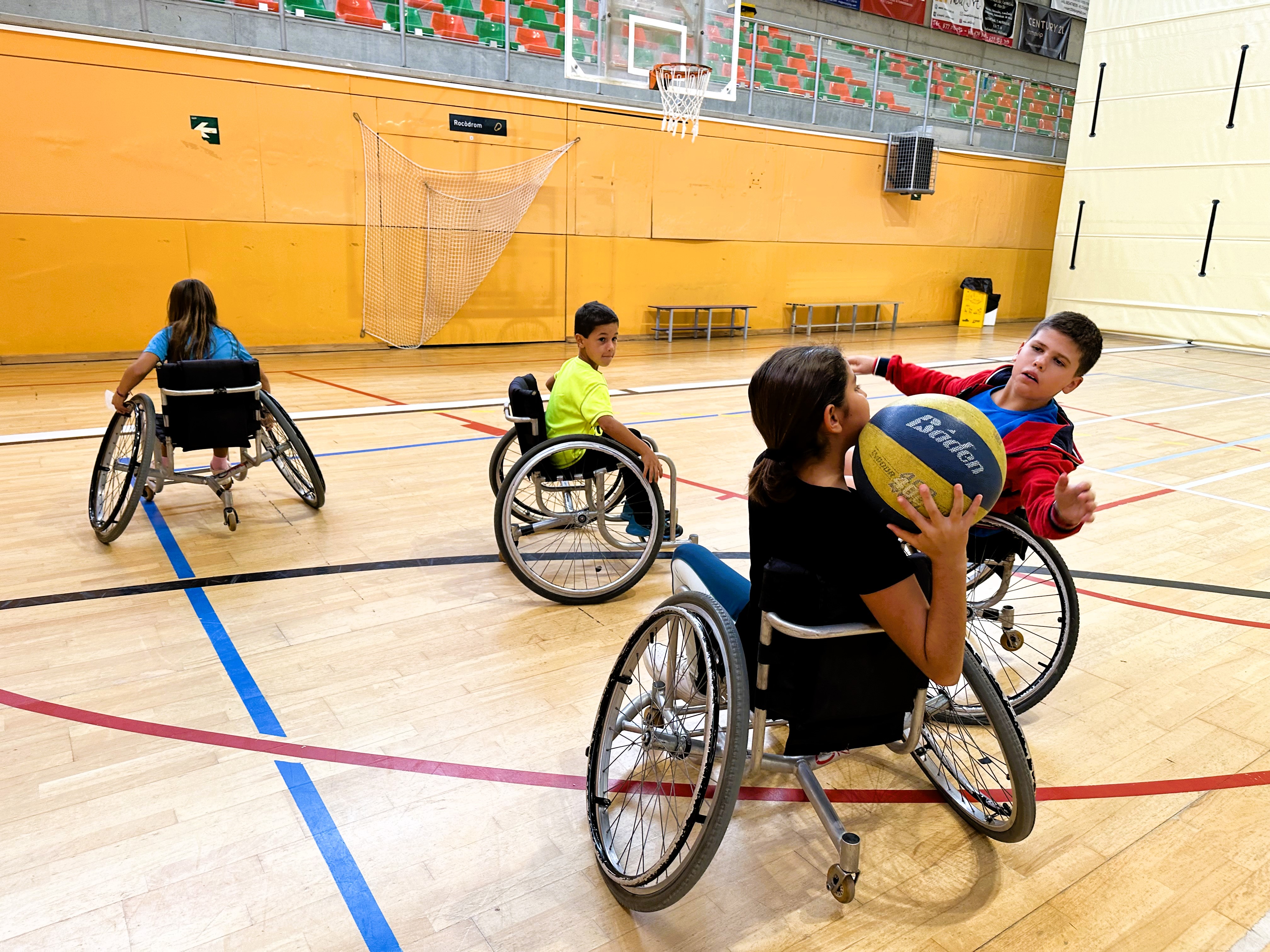 Foto d'alguns infants jugant a bàsquet adaptat durant la Festa de l'Esport
