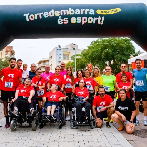 Usuaris i usuàries de la Fundació La Muntanyeta, amb els organitzadors, a la sortida de la cursa